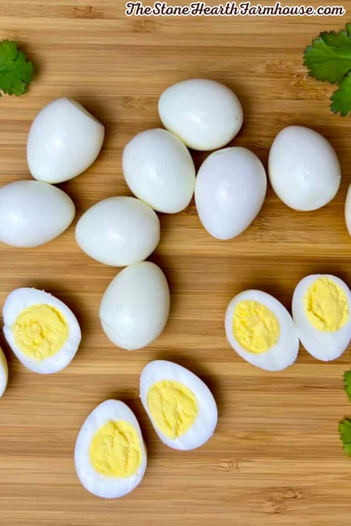 Peeled quail eggs with bright yellow yolks arranged on a wooden cutting board
