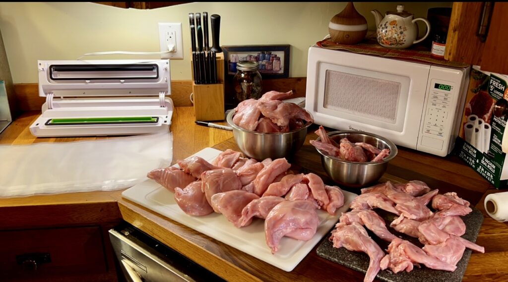 cut up rabbit meat on a counter ready to me packaged up with a food saver machine.