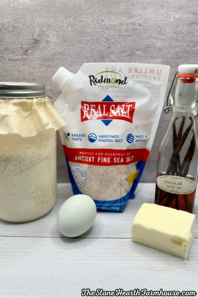 Ingredients for homemade sourdough pancakes including starter, butter, egg, salt, and vanilla