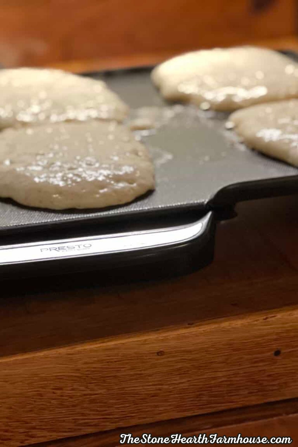 Sourdough pancake batter cooking on an electric griddle until golden and fluffy