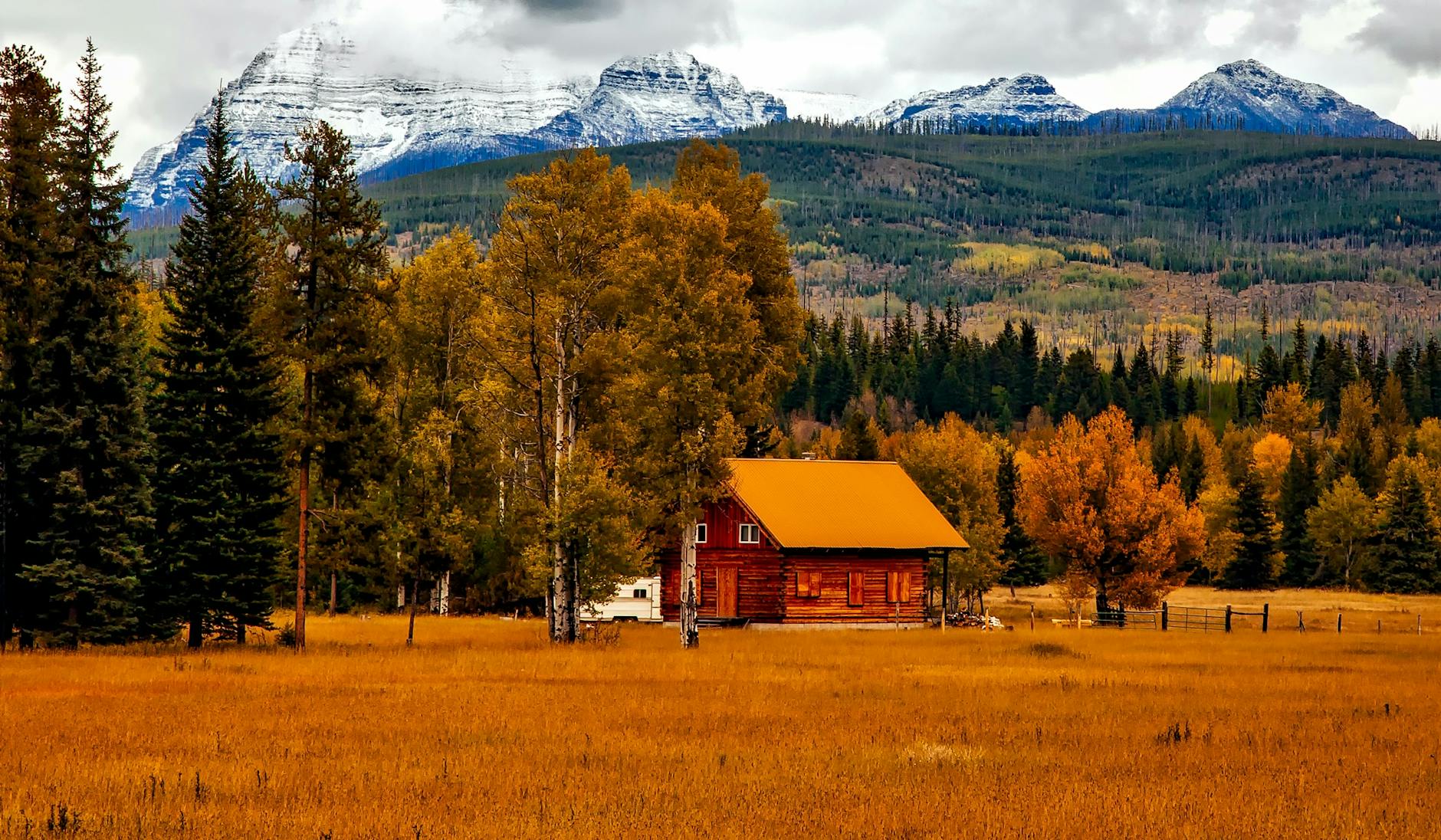 brown cabin near trees and mountains