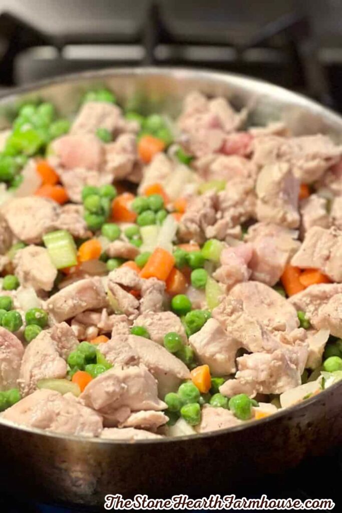 Tender cooked rabbit pieces sautéed with peas, carrots, and celery for a homemade pot pie