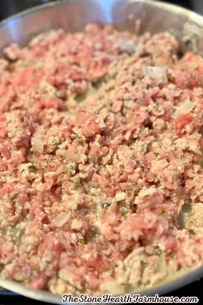 Seasoned ground rabbit and onions cooking in a skillet for a hearty shepherd’s pie filling