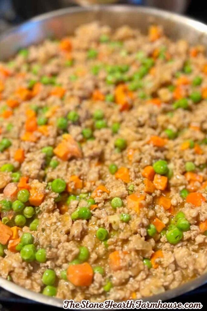 Ground rabbit cooked with peas and diced carrots in a savory sauce for shepherd’s pie