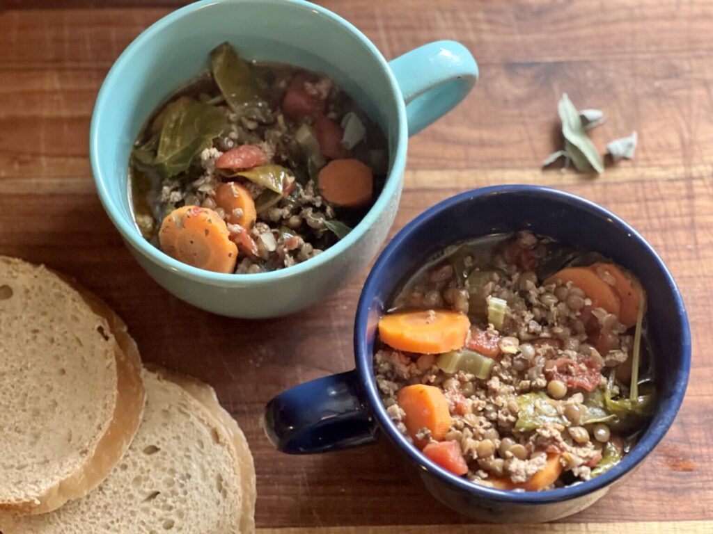 two bowls of lentil soup with a couple slices of bread ready to eat