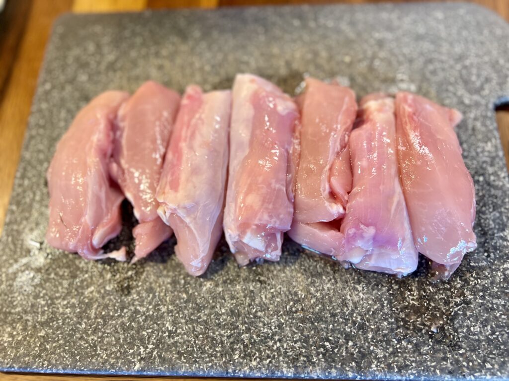 rabbit meat tenders in a row on a cutting board.