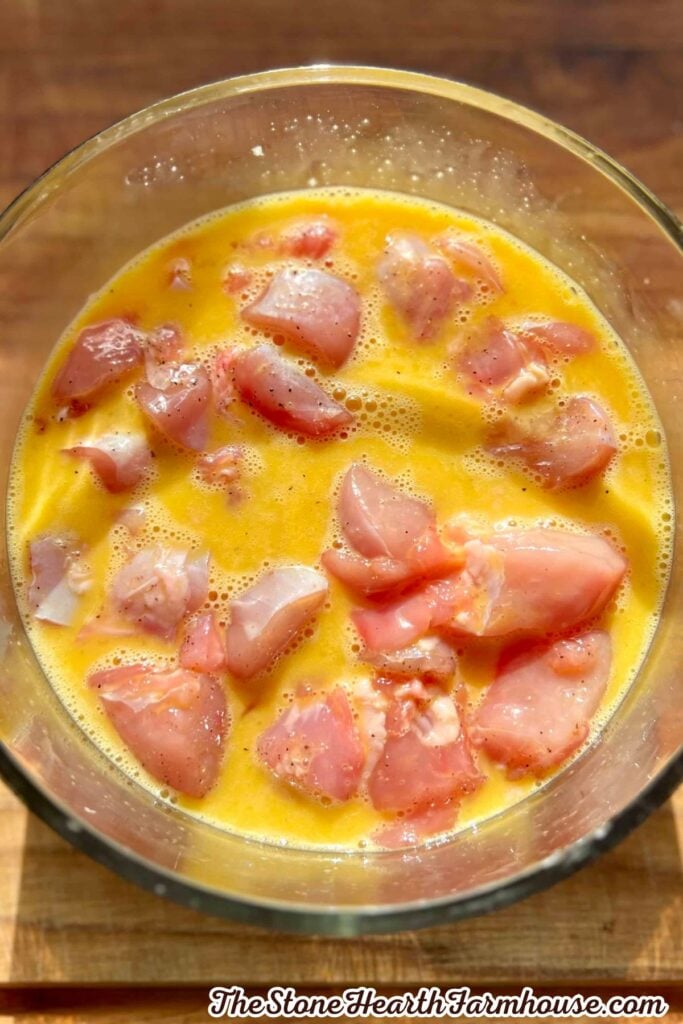 Cut rabbit meat soaking in beaten egg before being dredged in seasoned flour