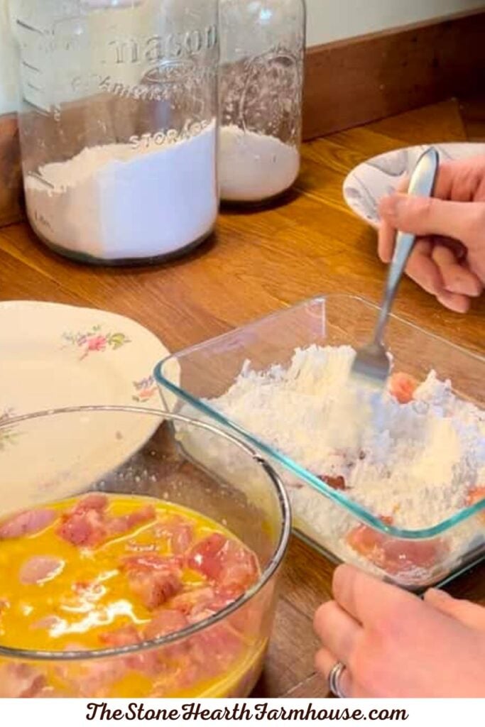 Diced rabbit meat being coated in flour before frying for a crispy rabbit recipe