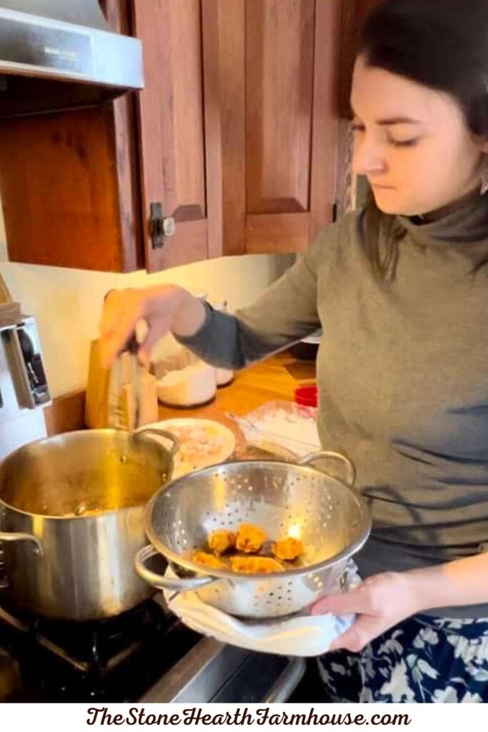 Preparing crispy rabbit pieces in a pot of hot oil for a homemade firecracker rabbit recipe