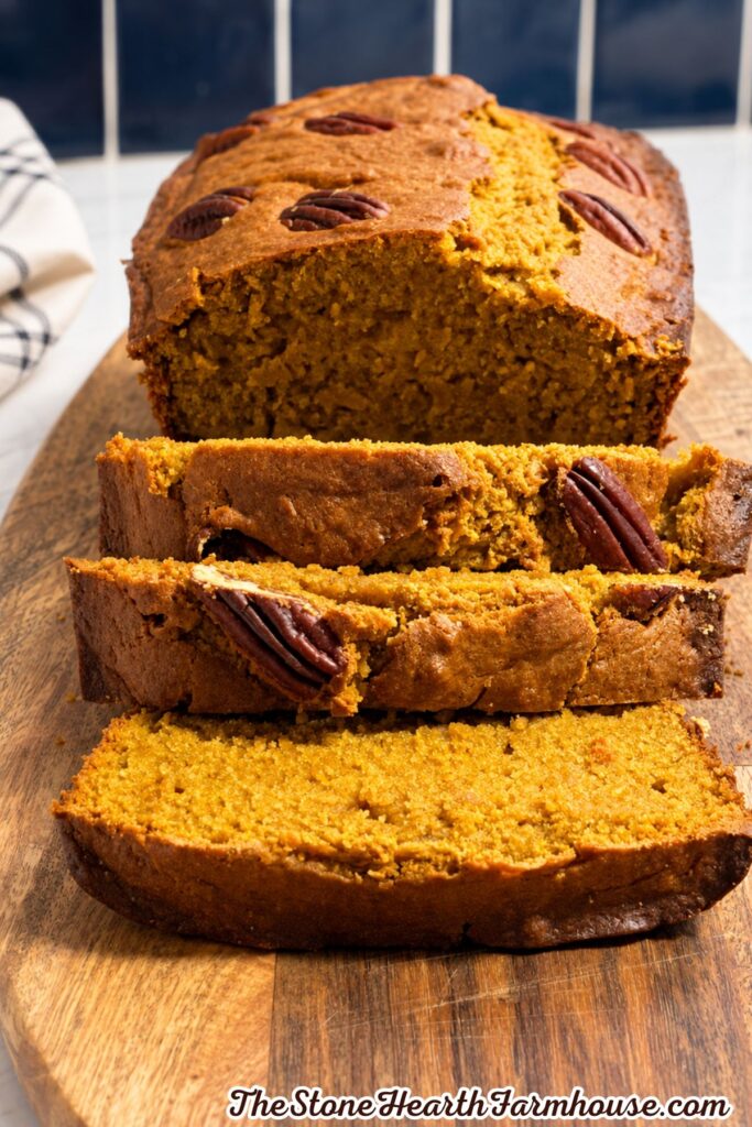 Rustic loaf of pumpkin bread sliced to show its moist golden-orange interior