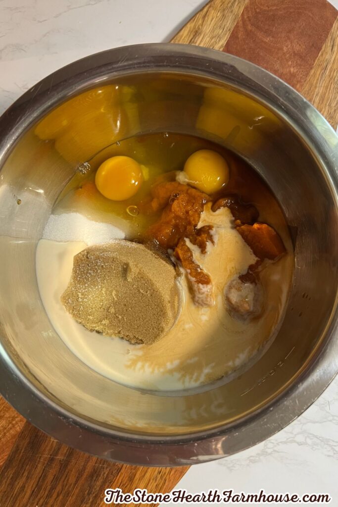 Mixing bowl filled with pumpkin bread ingredients including eggs, pumpkin puree, brown sugar, and milk.