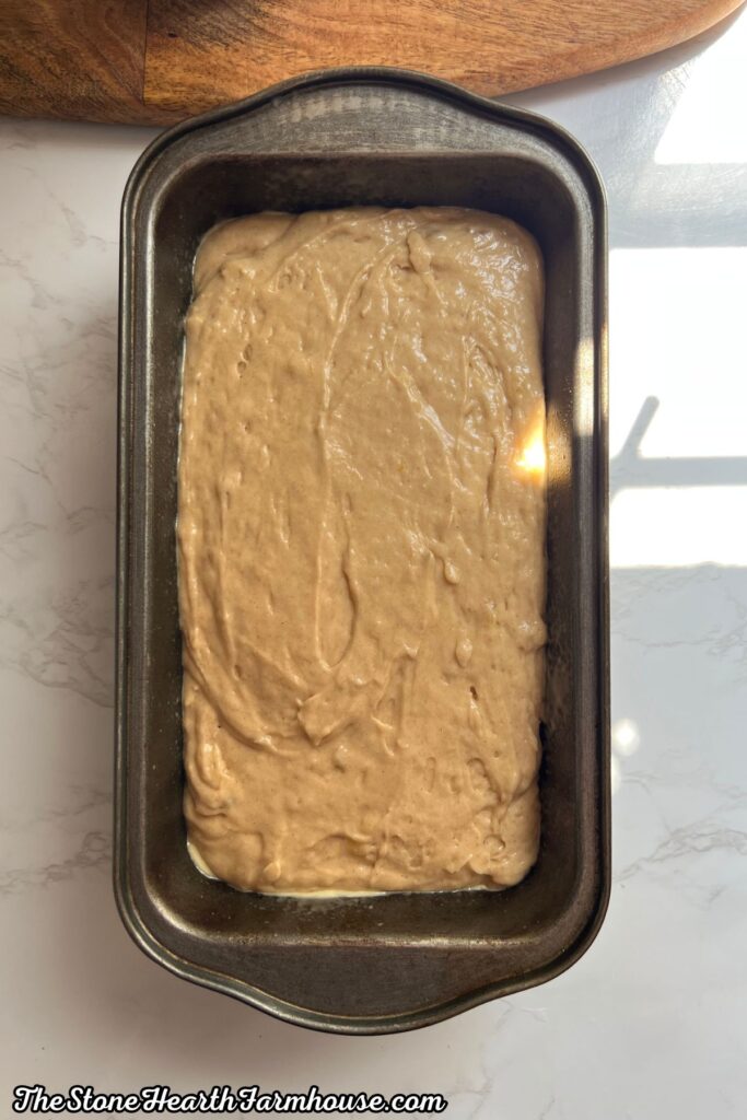 Alt text: Thick banana bread batter spread evenly in a loaf pan before baking