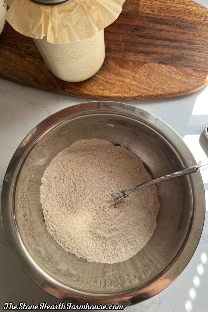 Flour mixture for sourdough banana bread stirred together in a stainless steel bowl