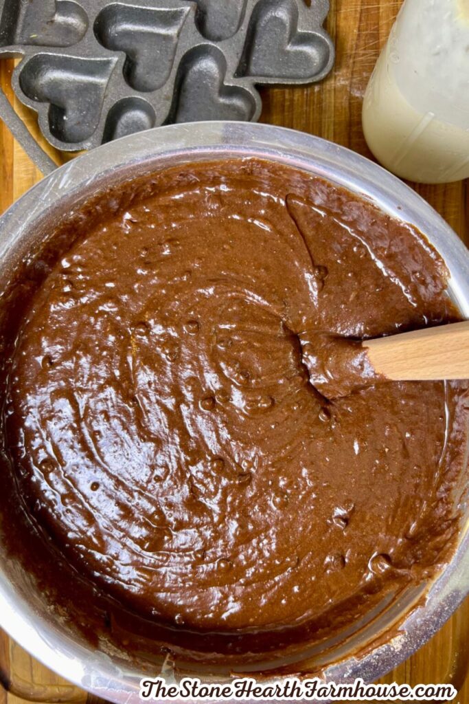 Sourdough discard brownie batter being spread smooth in a mixing bowl