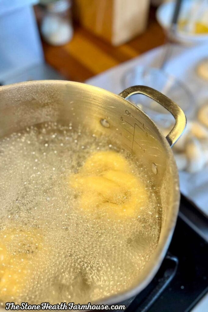 Soft pretzels boiling in water before baking to create a chewy golden crust