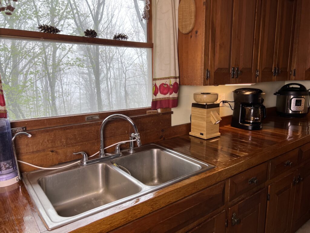 Handcrafted oak wood countertops made from hardwood flooring in a kitchen, featuring matching solid wood cabinets, window above the sink.