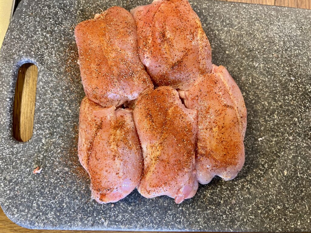 Boneless Rabbit thighs on a cutting board, seasoned and ready to be cooked.