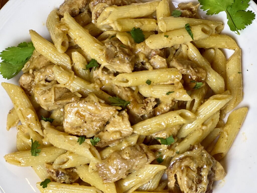 Close up of Creamy Merry Me Chicken on a white plate.