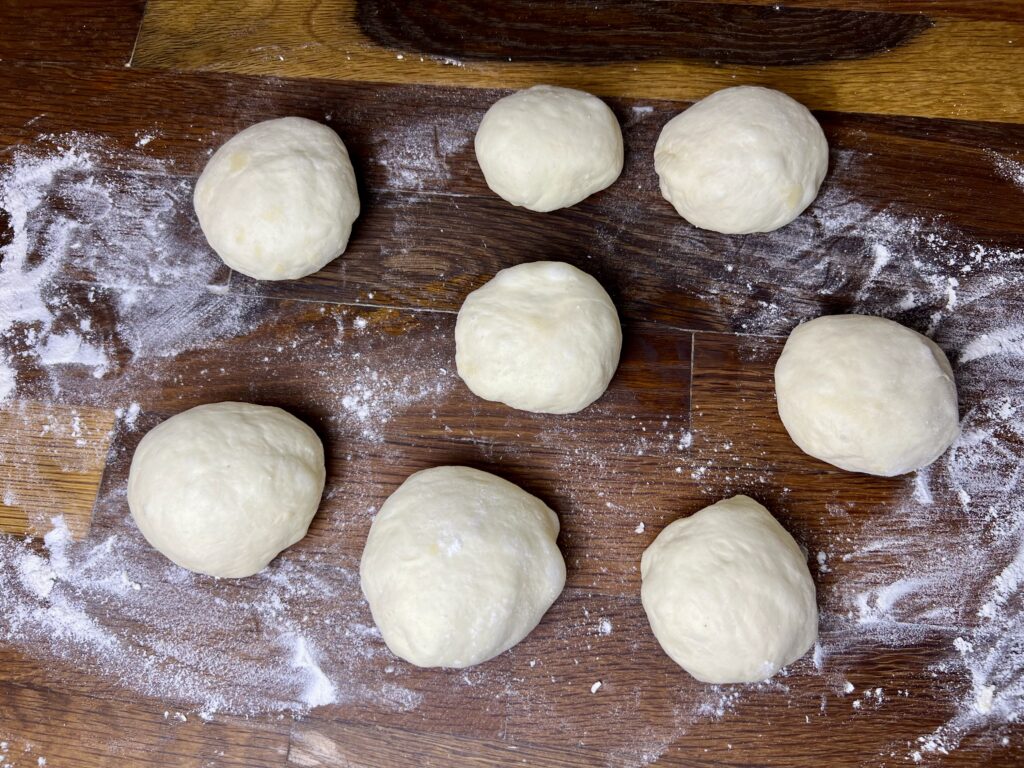 8 small dough balls ready to be shaped into bagels.