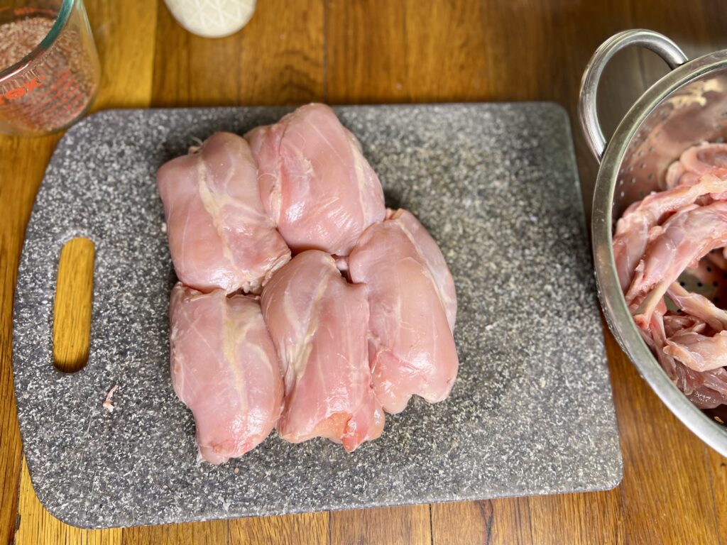 Boneless rabbits meat on a cutting board. Looks very similar to chicken thighs.