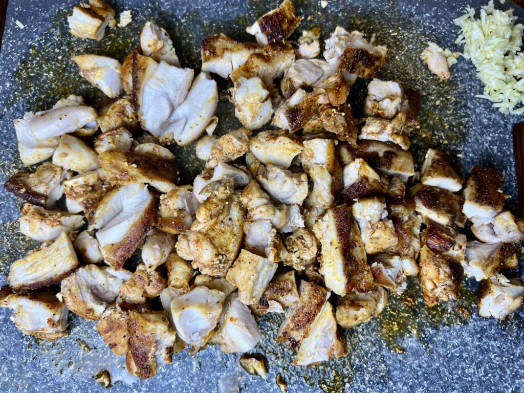 rabbit meat cooked and diced on a cutting board.