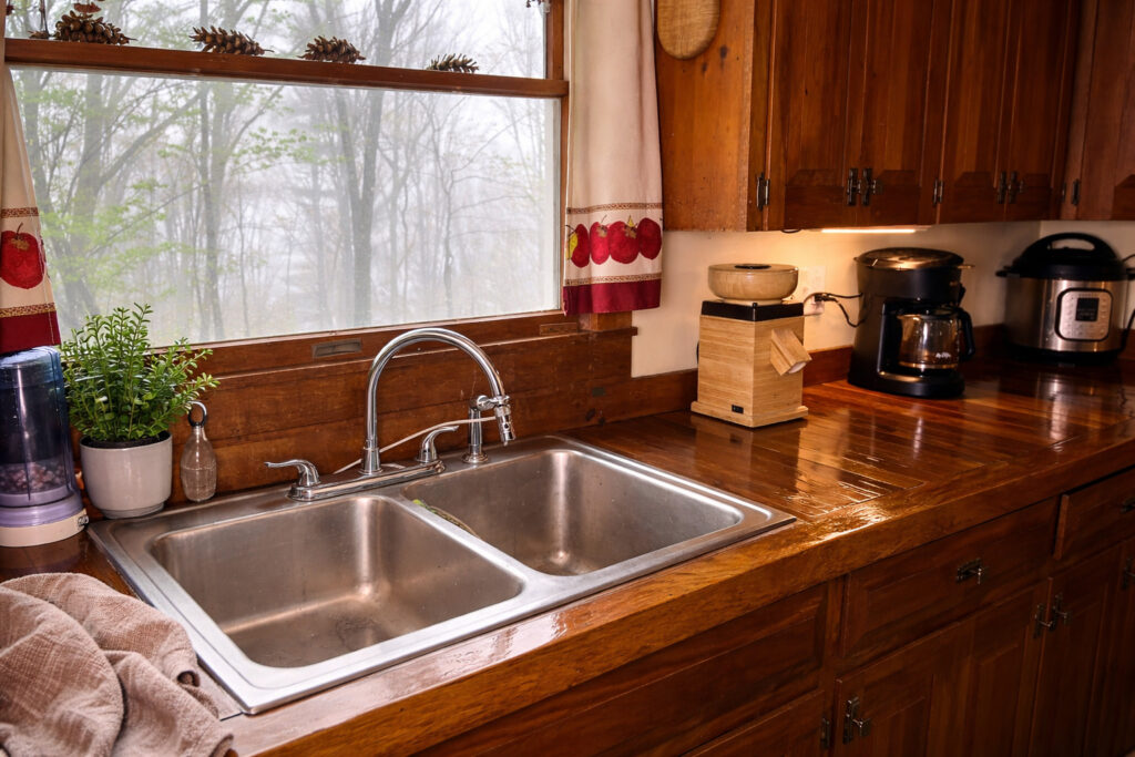 Handcrafted oak wood countertops made from hardwood flooring in a kitchen, featuring matching solid wood cabinets, window above the sink.