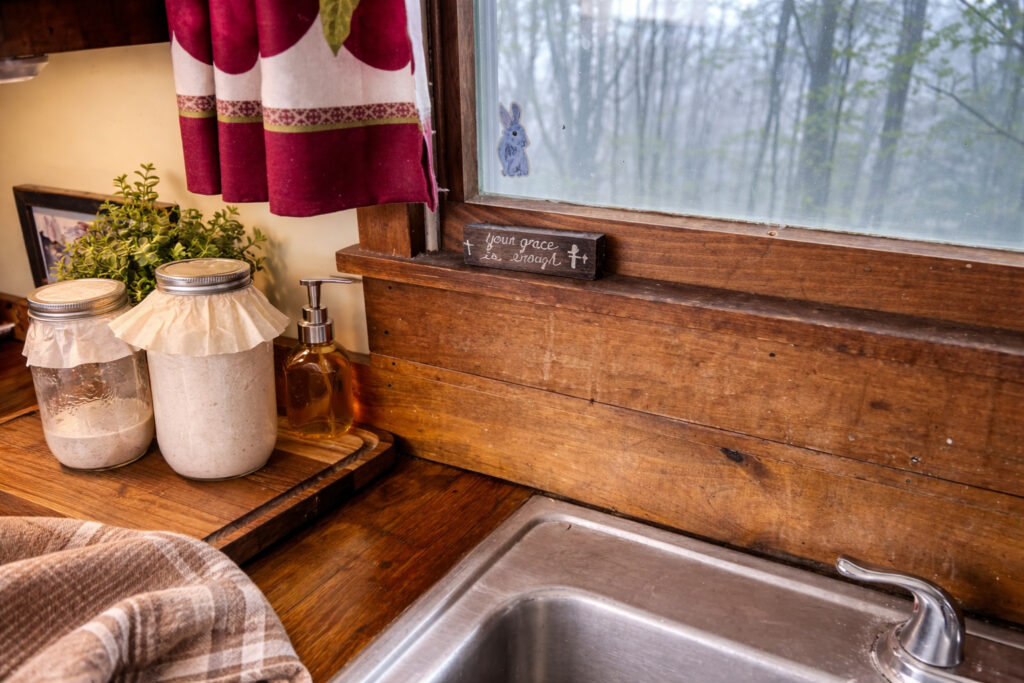 Handcrafted oak wood countertops made from hardwood flooring in a traditional kitchen, a farmhouse-style window above the sink.