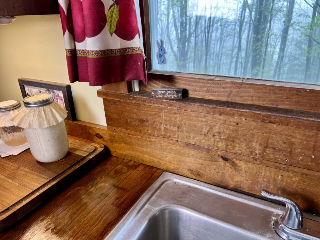 Handcrafted oak wood countertops made from hardwood flooring in a traditional kitchen, a farmhouse-style window above the sink.