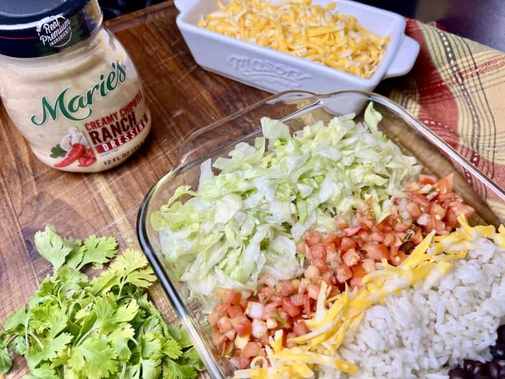 featuring the salad with dressing container next to it and the cheese in a separate container.