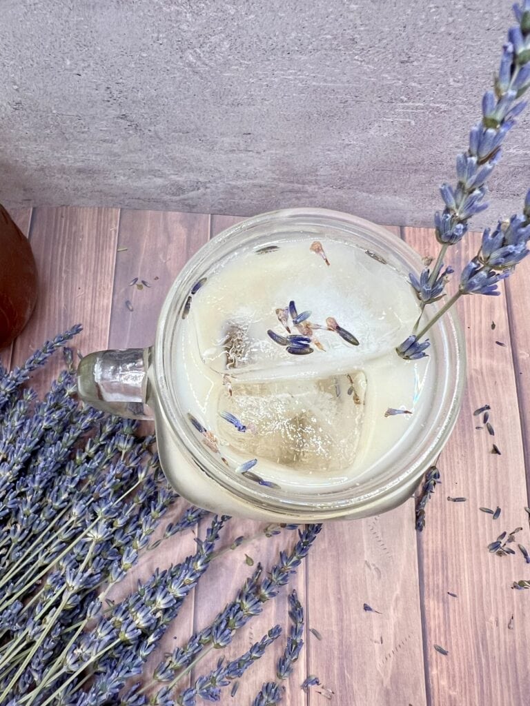 Lavender latte in a jar with lavender flowers.