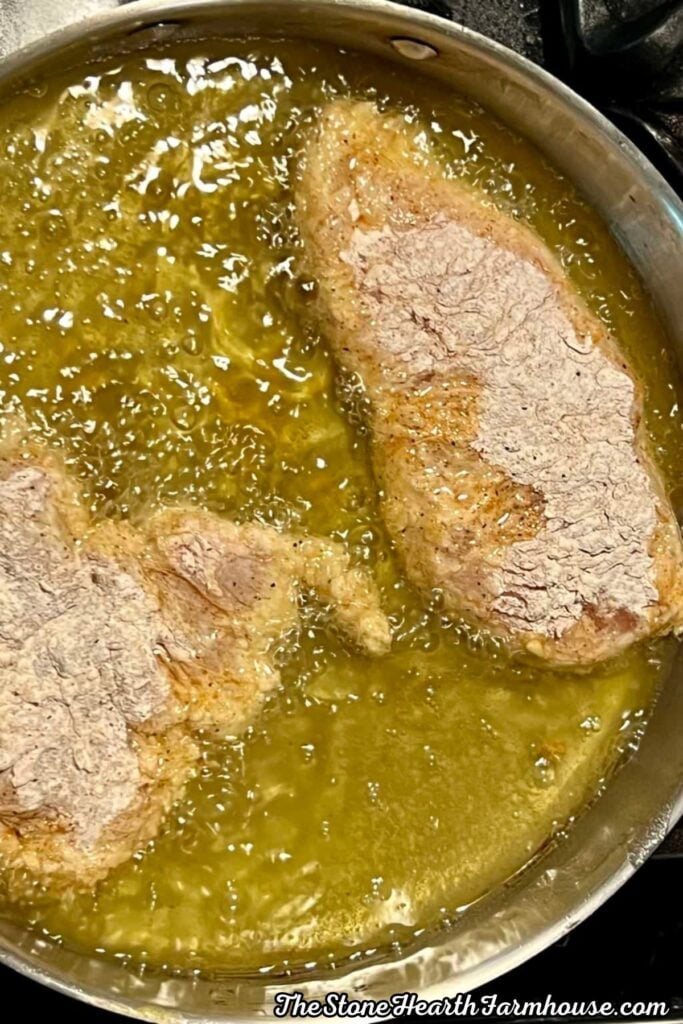 Breaded chicken breasts frying in hot oil for a crispy buttermilk chicken sandwich