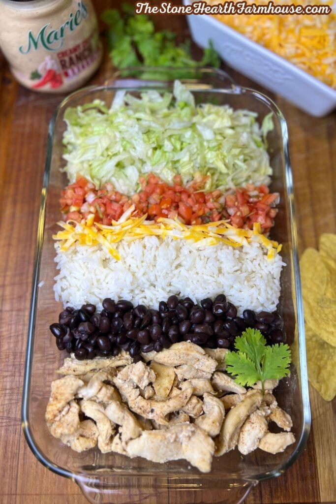 Southwest chicken salad layered with lettuce, pico de gallo, shredded cheese, white rice, black beans, and seasoned chicken