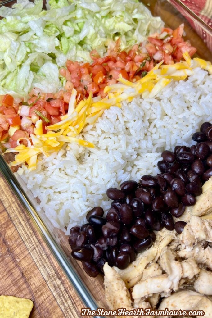Close-up of Southwest chicken salad with fresh lettuce, pico de gallo, shredded cheese, rice, black beans, and seasoned chicken