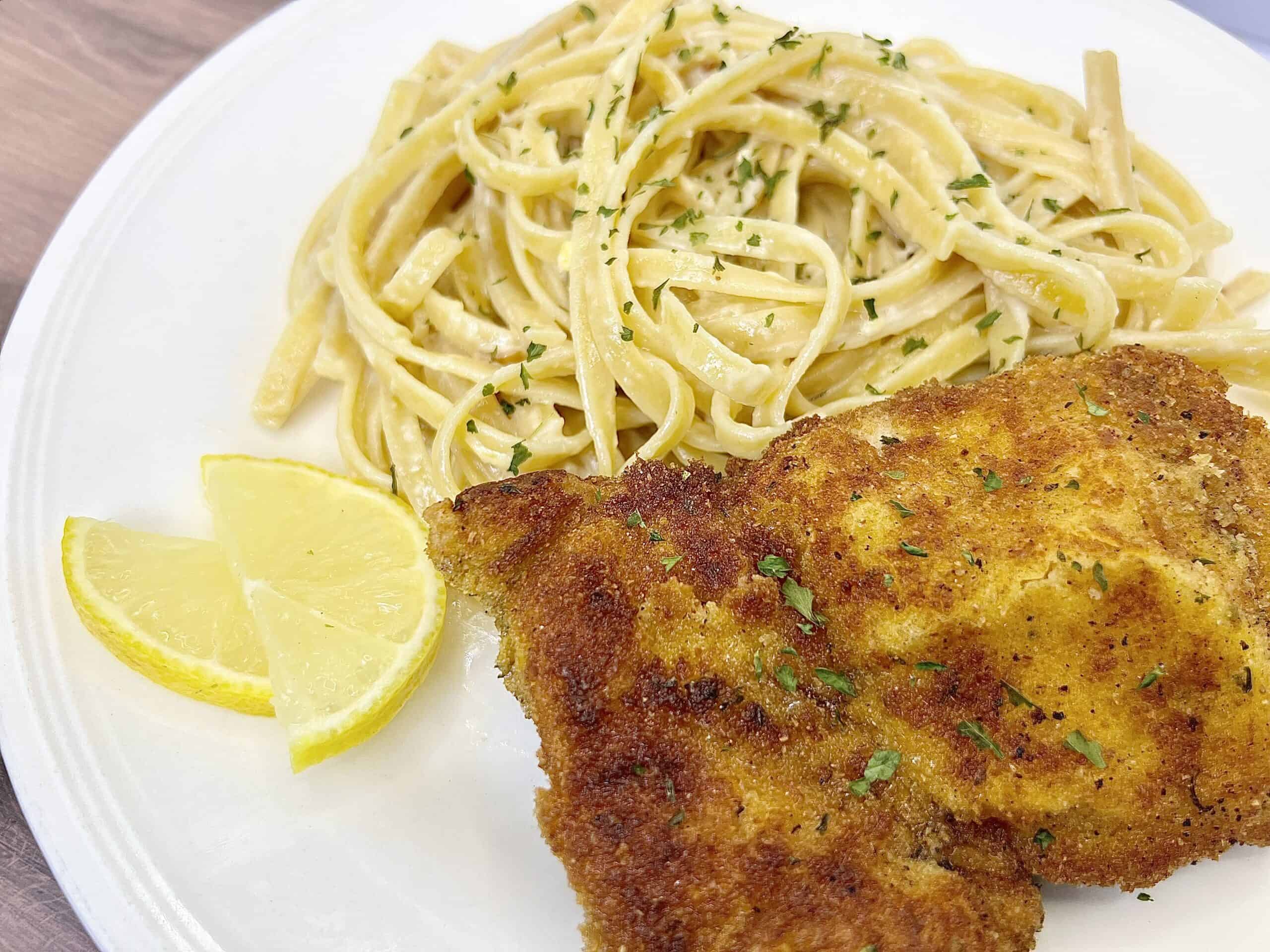 A plate with a chicken cutlet and pasta.