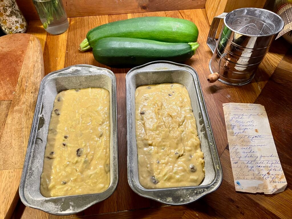 zucchini bread batter in two loaf pans, ready to be baked.