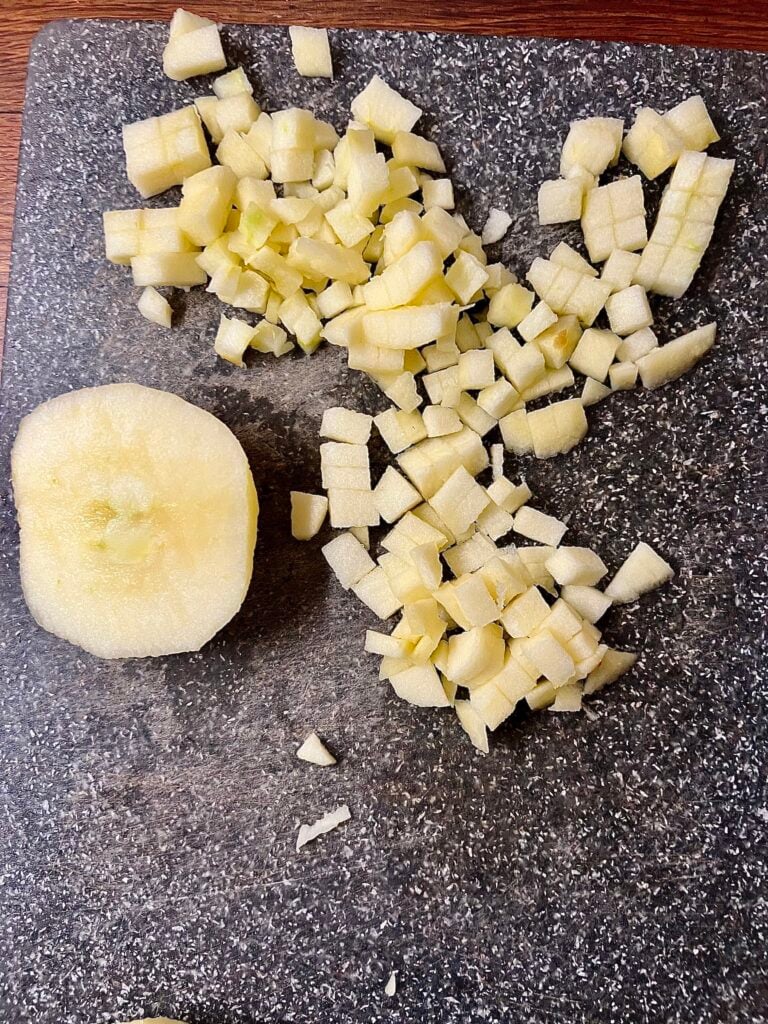 Pealed and diced apple on a cutting board to show how small to Dice the apple. 