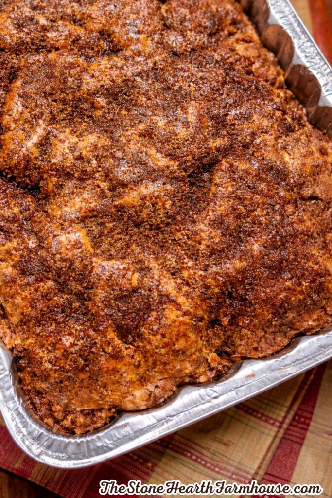 Homemade pumpkin coffee cake baked with a golden brown cinnamon streusel topping in a foil pan.
