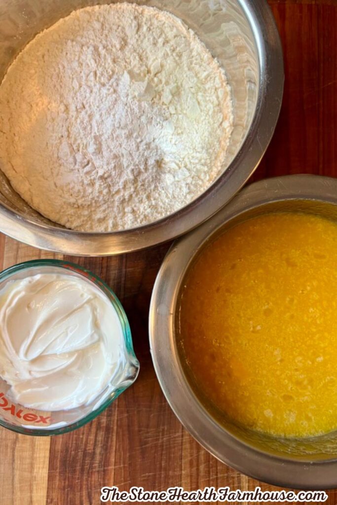 Baking ingredients including flour, melted butter, and sour cream prepared for a homemade coffee cake.