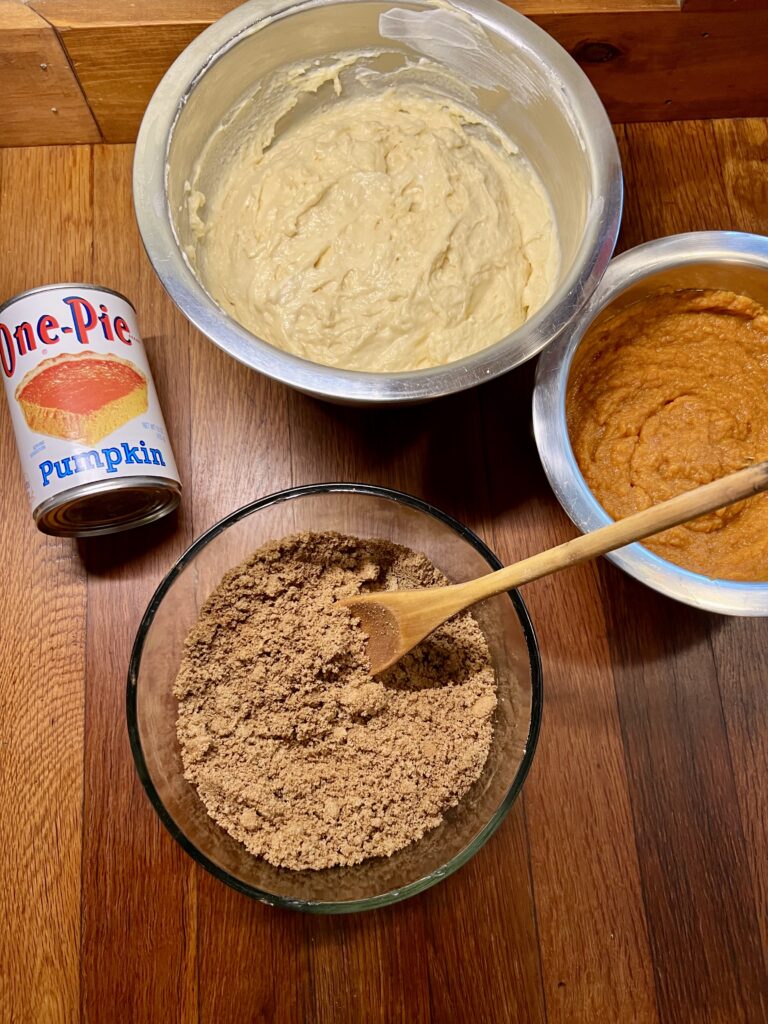 Showing three bowls. One filled with pumpkin coffee cake batter, another filled with the Cinnamon streusel topping. And the last bowl is the pumpkin filling. 
