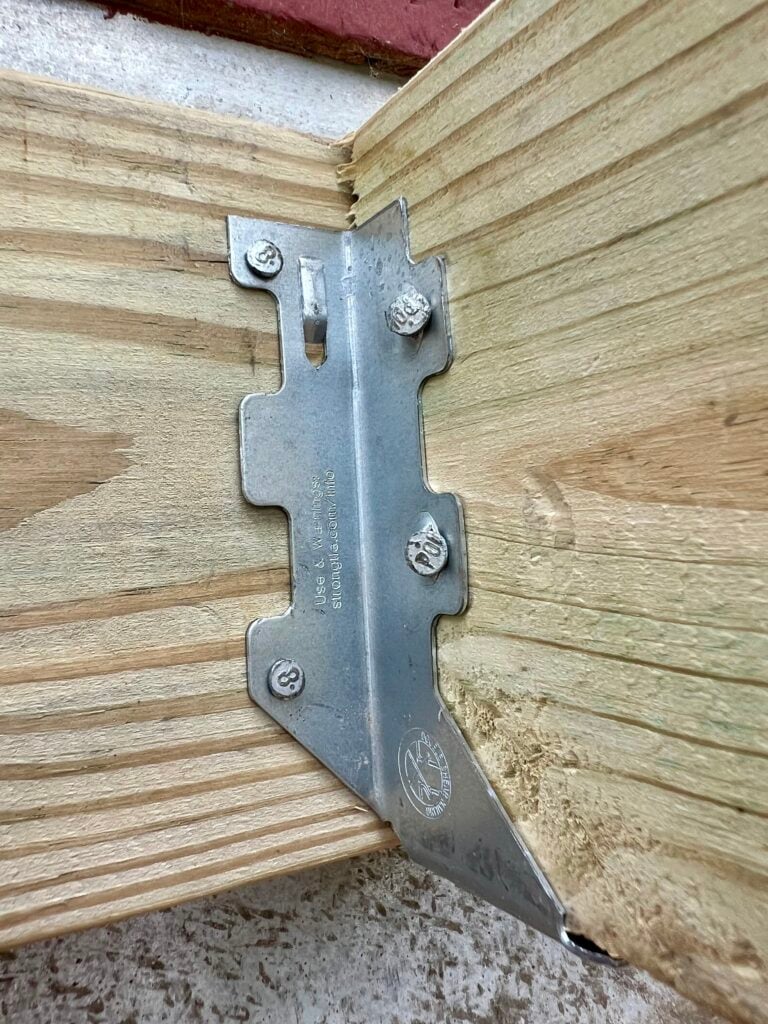 Close-up of metal joist hanger hardware used in DIY deck framing for Trex decking