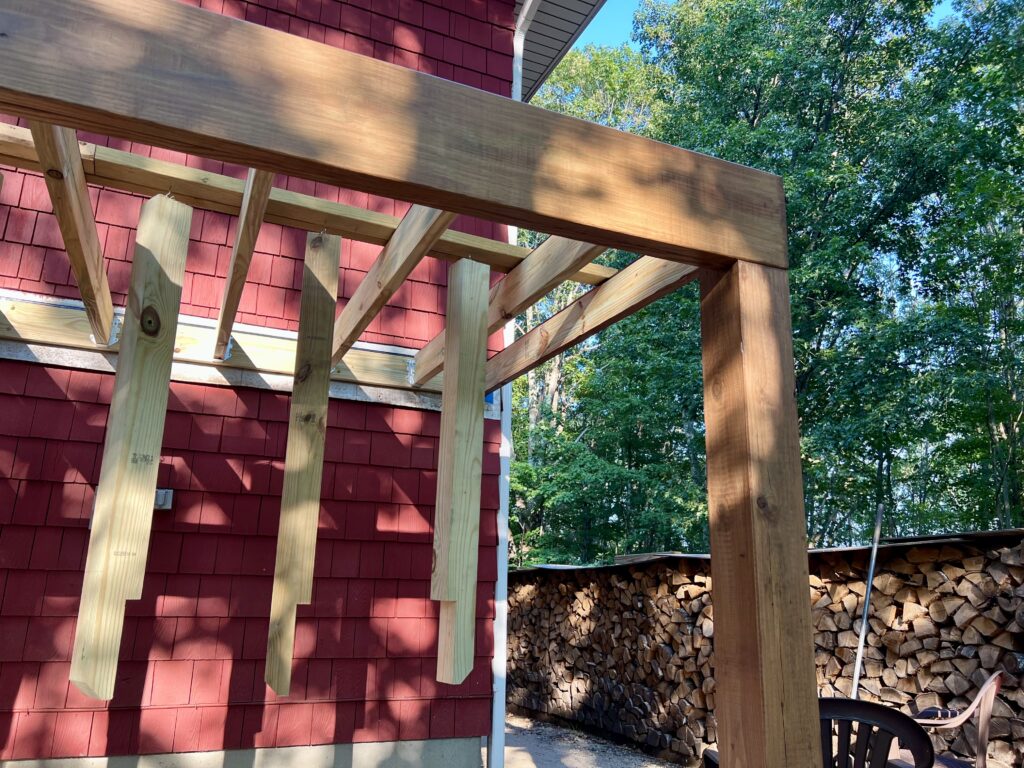 Side view of stained deck beam with joists installed on DIY deck project