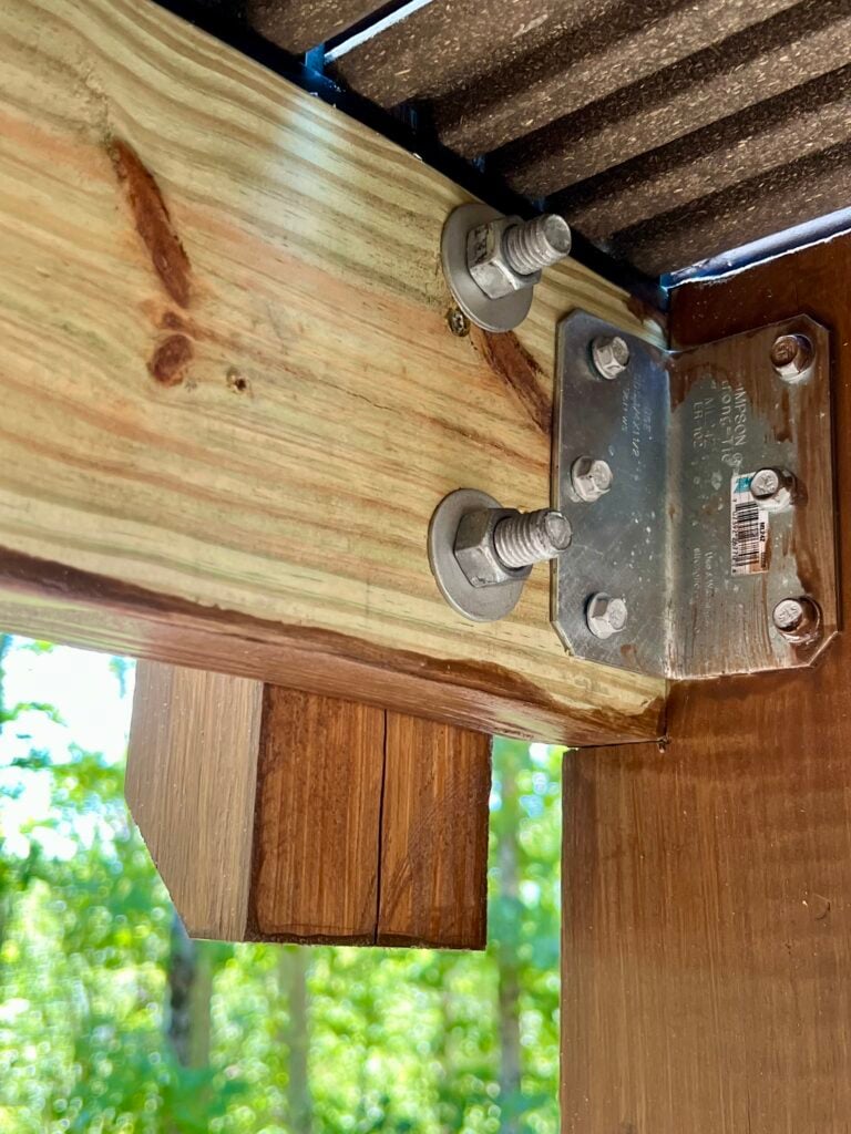 Underside view of deck beam secured to post with metal connector hardware
