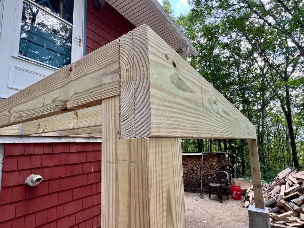 End view of deck beam resting on pressure-treated post in DIY deck build