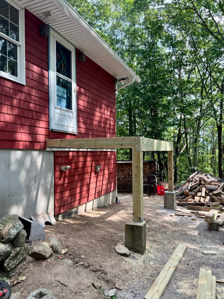 Pressure treated deck posts set on concrete piers for DIY Trex deck build
