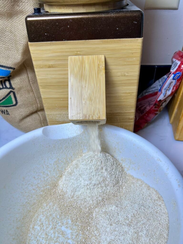 soft white wheat berries being ground into fresh milled four to bake brown butter chocolate chip cookies. 