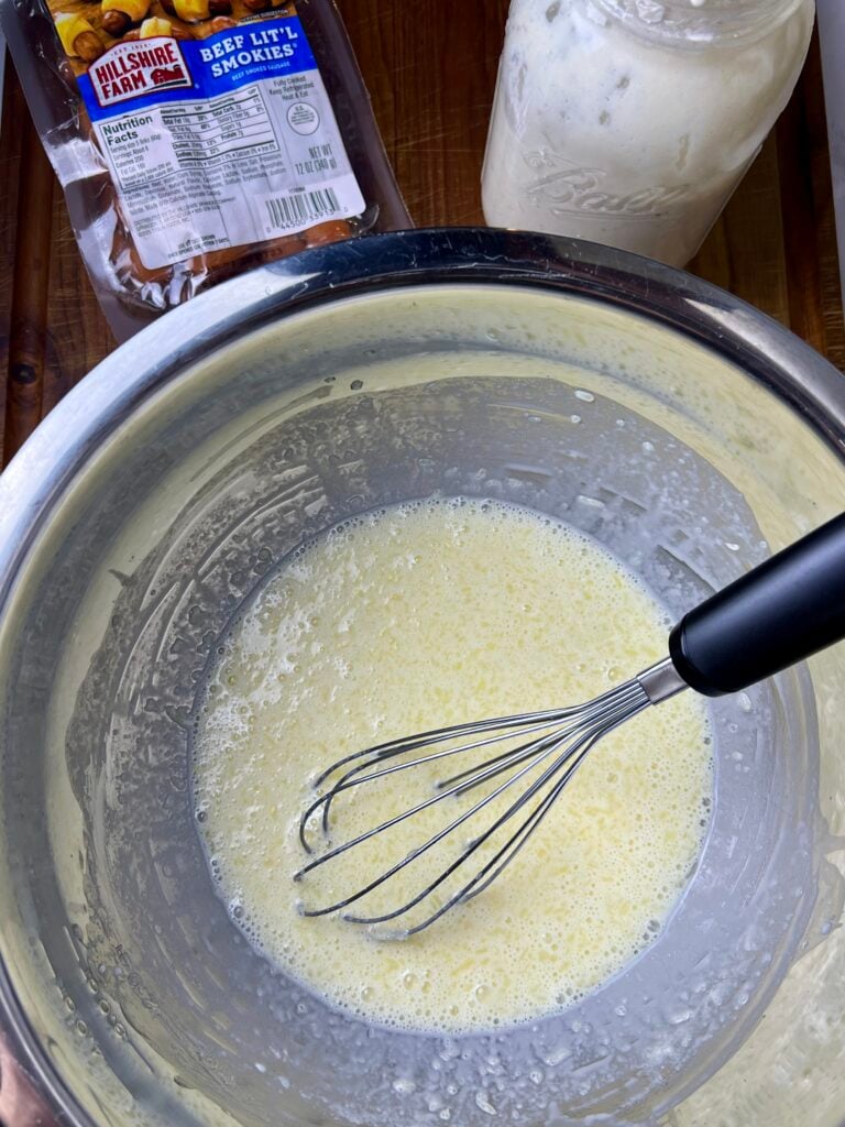 wet ingredients mixed together in a stainless steel bowl, with a whisk. 