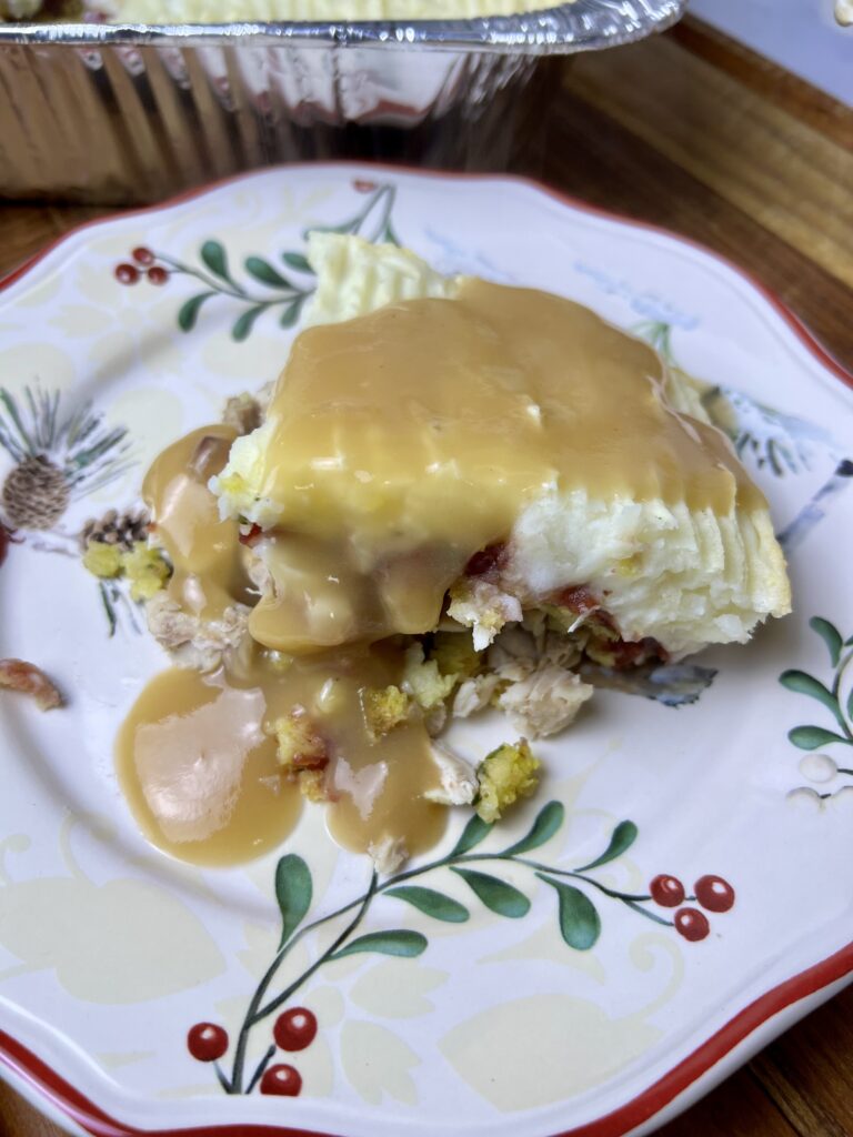Close-up of thanksgiving lasagna layers with leftover turkey, stuffing, cranberry sauce, mashed potatoes, and gravy