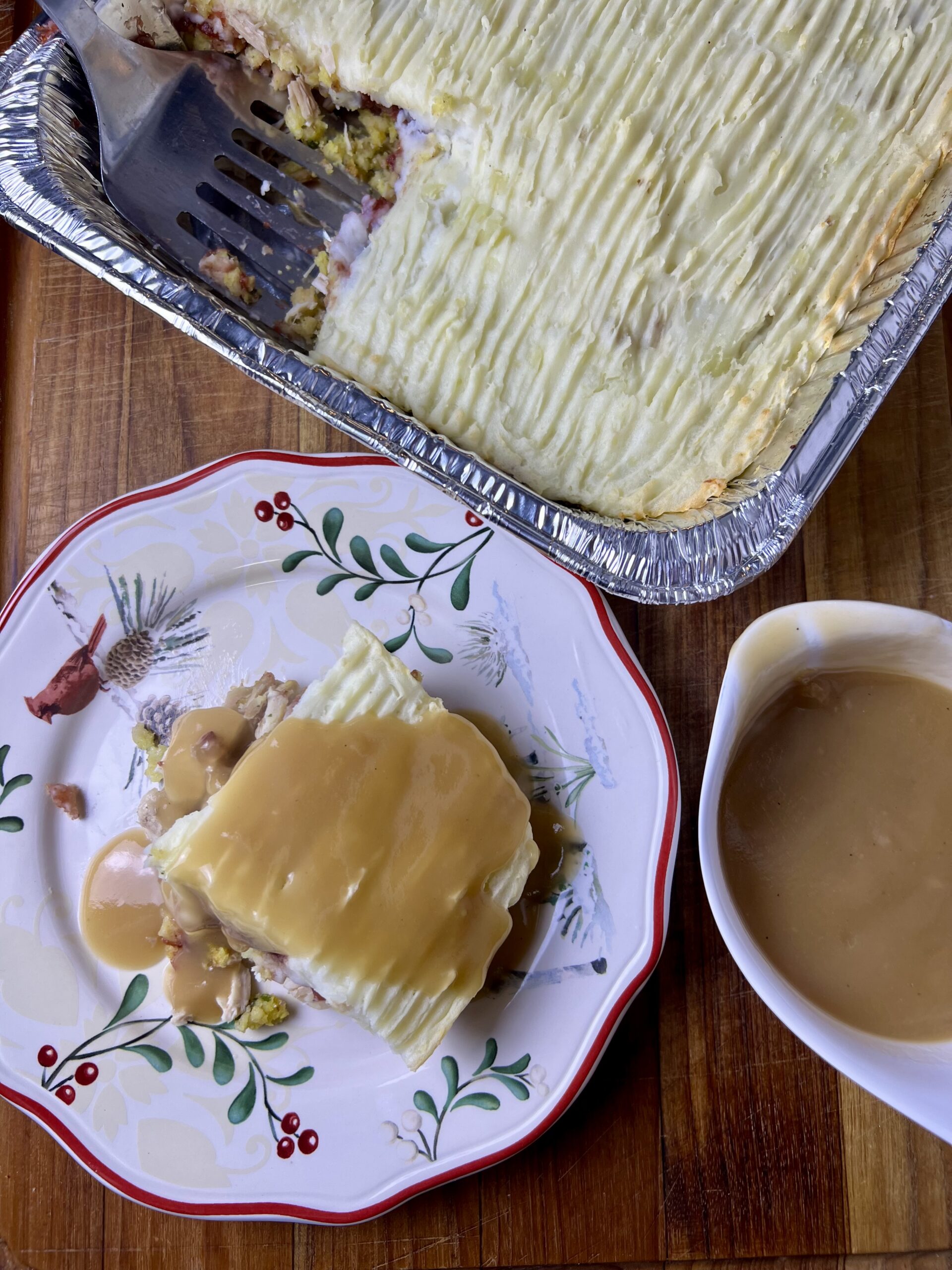 Thanksgiving leftover lasagna served with gravy, made as a layered thanksgiving casserole with turkey, stuffing, cranberry sauce, and mashed potatoes