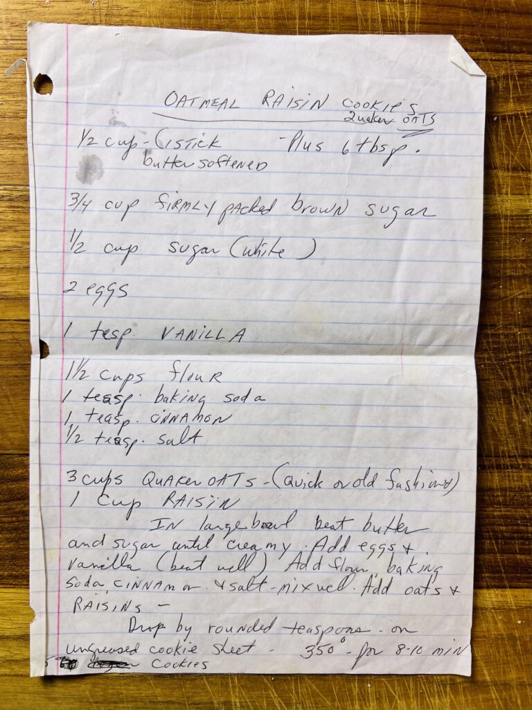 Handwritten oatmeal raisin cookie recipe on lined paper with ingredient measurements and baking instructions