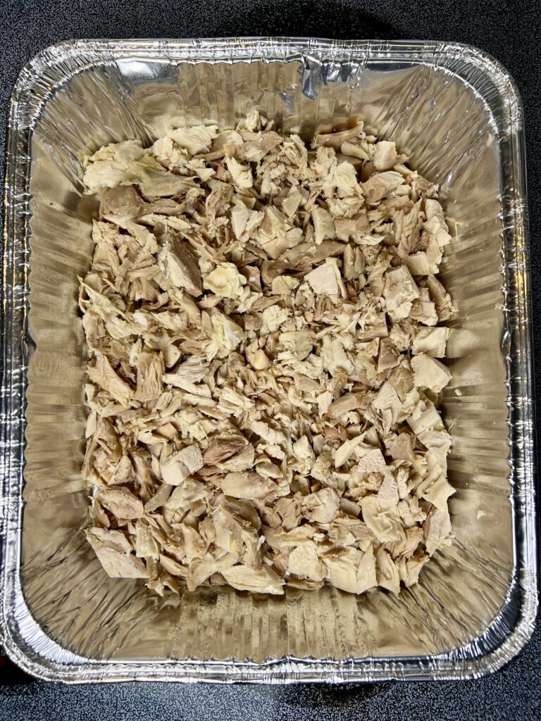 Shredded leftover turkey layered in a thanksgiving leftover casserole before baking